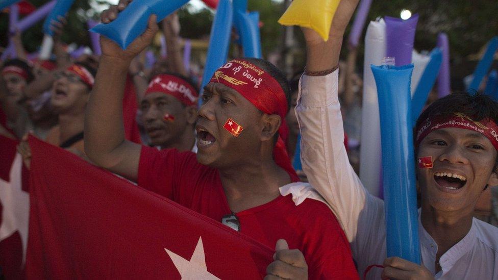 Supporters of Myanmar opposition leader Aung San Suu Kyi celebrating as they look at the official election results on a giant screen in Yangon