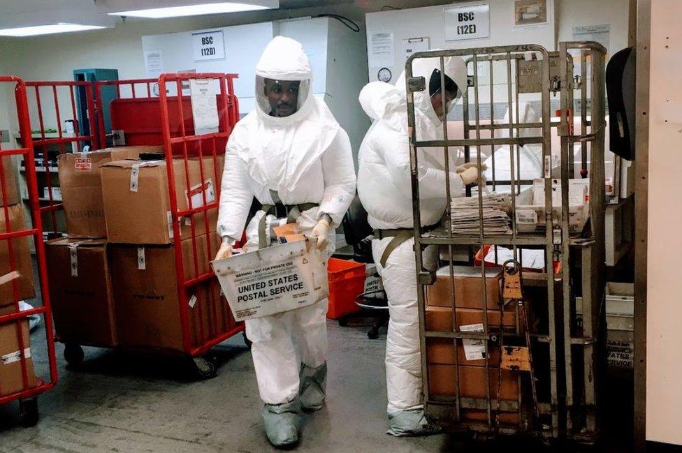 Pentagon officials wear protective suits as they inspect the quarantined mailroom