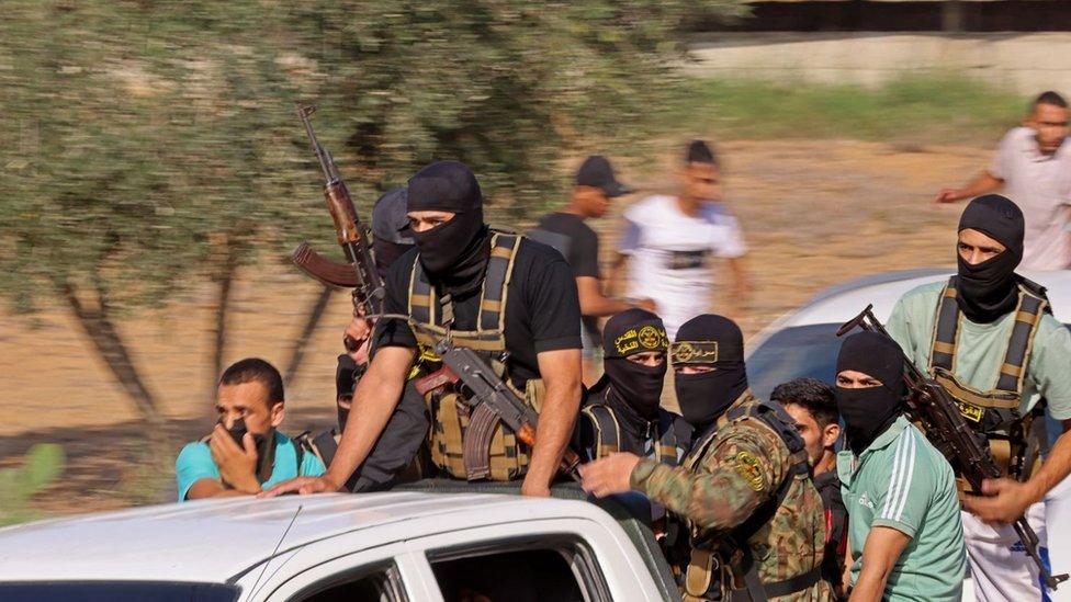 Palestinian militants move towards the border fence with Israel from Khan Yunis in the southern Gaza Strip on October 7, 2023.