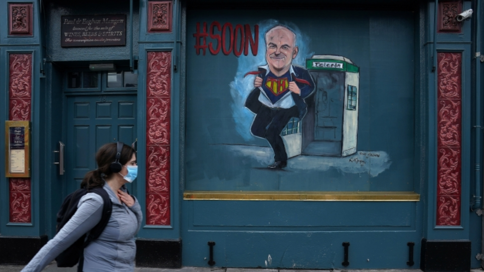 Woman walks past a closed pub in Dublin