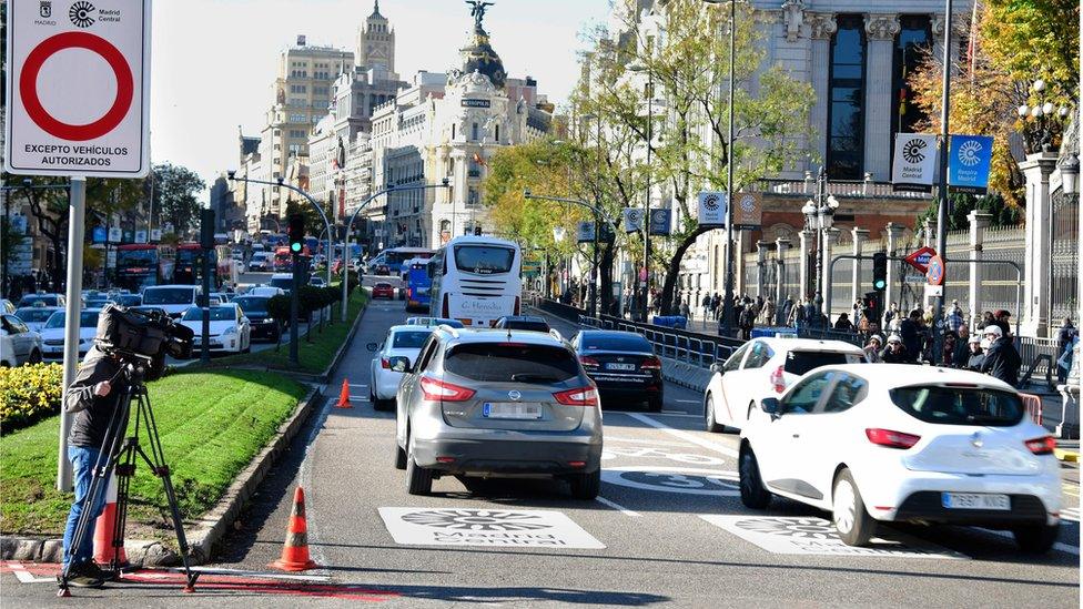 Cars pass signs reading "Madrid Central" in the Spanish capital, 30 November 2018