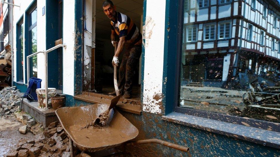 Man removes mud from property in Bad Muenstereifel