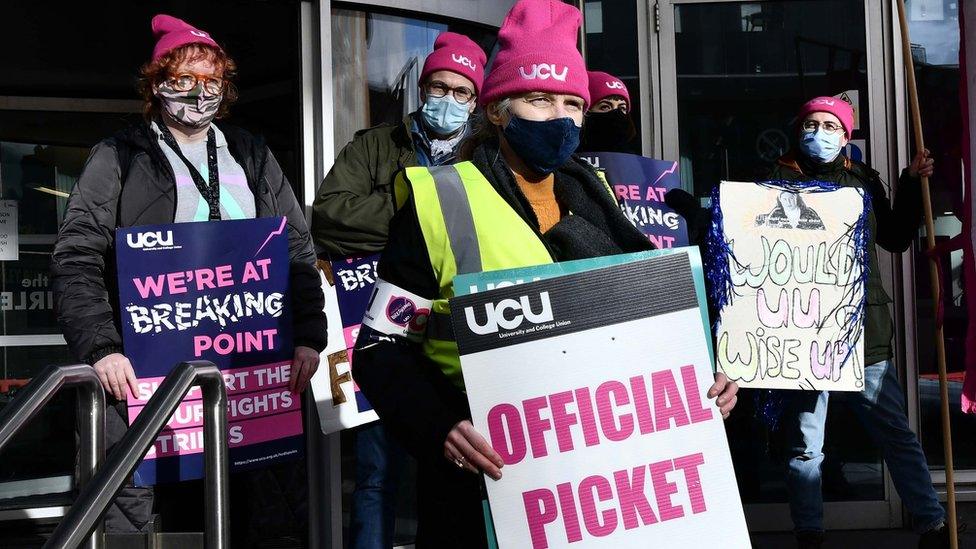 University staff holding placards