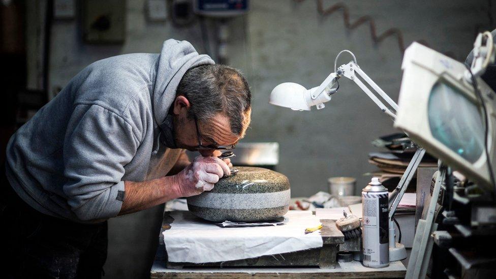 Production supervisor John Brown hand-finishes a stone in the workshop