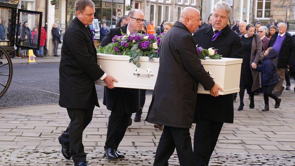 Holly's coffin being carried