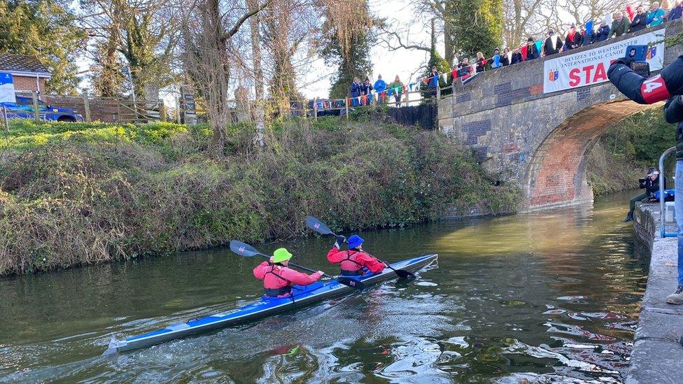 Canoeists paddling towards bridge