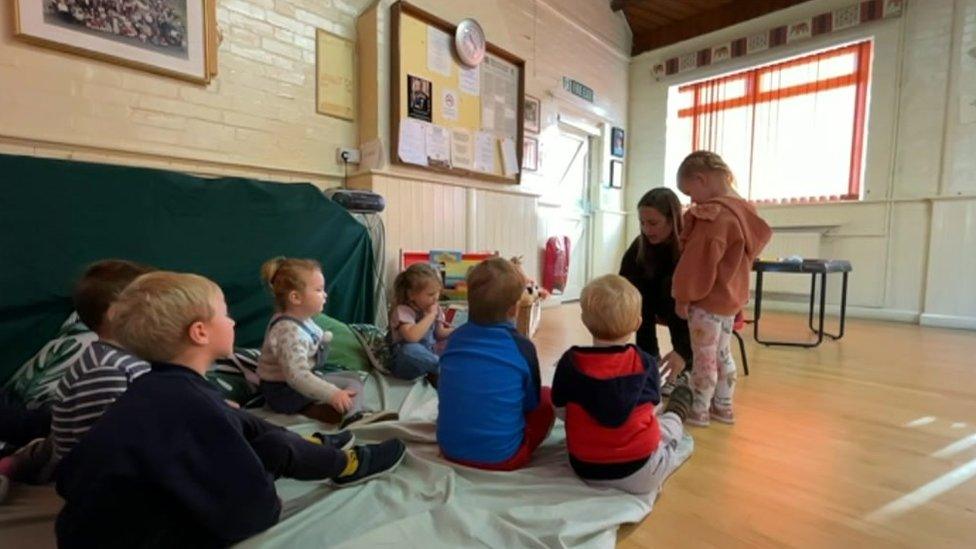 Children in temporary village hall classroom