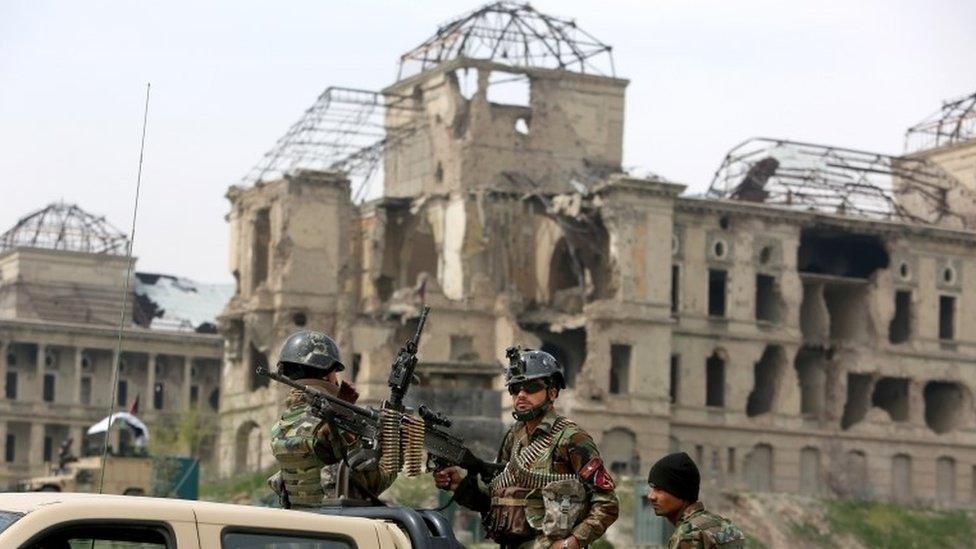 Afghan military soldiers stand stand alert at the entrance gate of the new parliament building after a rocket attack in Kabul, Afghanistan, Monday, March 28, 2016.