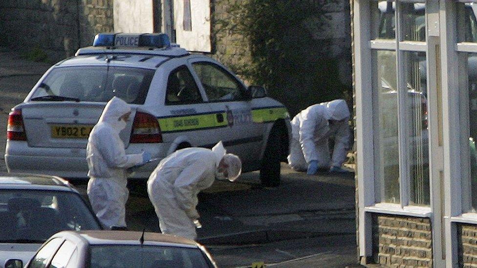 Police officers examiner the scene of the shooting