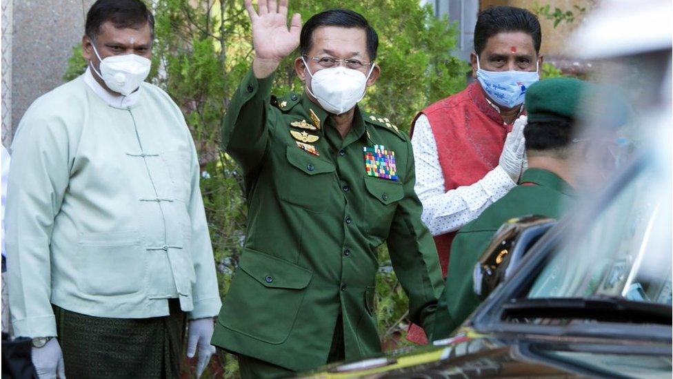 Myanmar's commander-in-chief Senior General Min Aung Hlaing waves to journalists after visiting the Sri Sri Durga Bari Hindu temple in Yangon