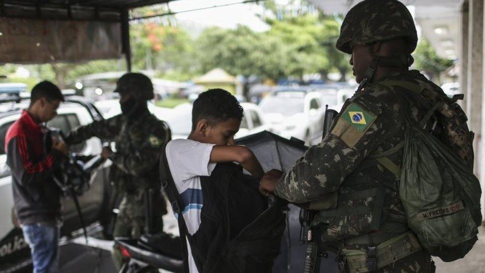 A soldier controls passers-by in Rio de Janeiro, Brazil, 23 February 2018.