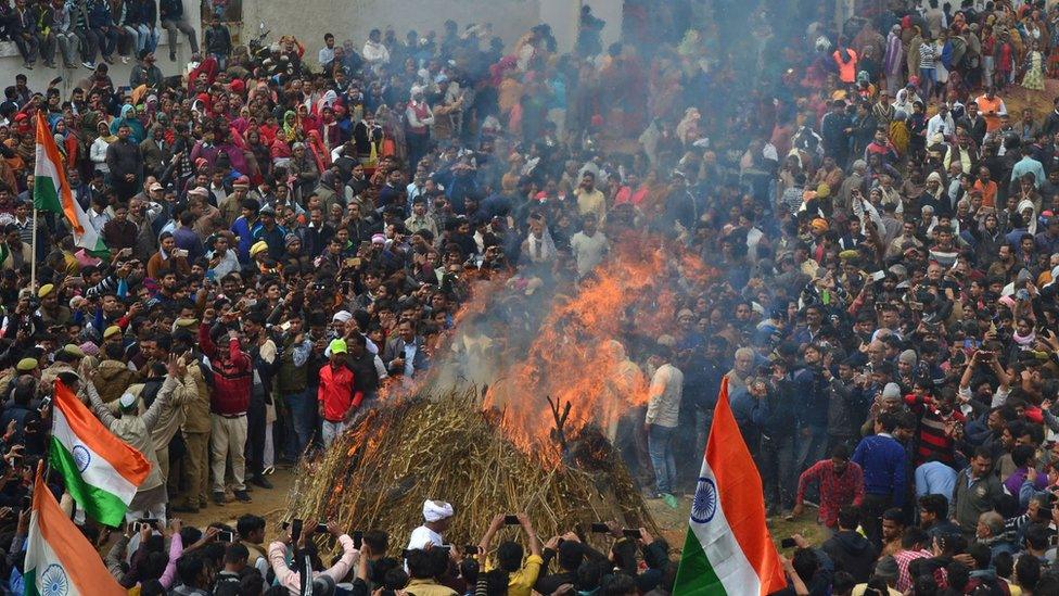 Mourners gather to watch the cremation at the funeral for Indian Central Reserve Police Force (CRPF) trooper Kaushal Kumar Rawat in Agra