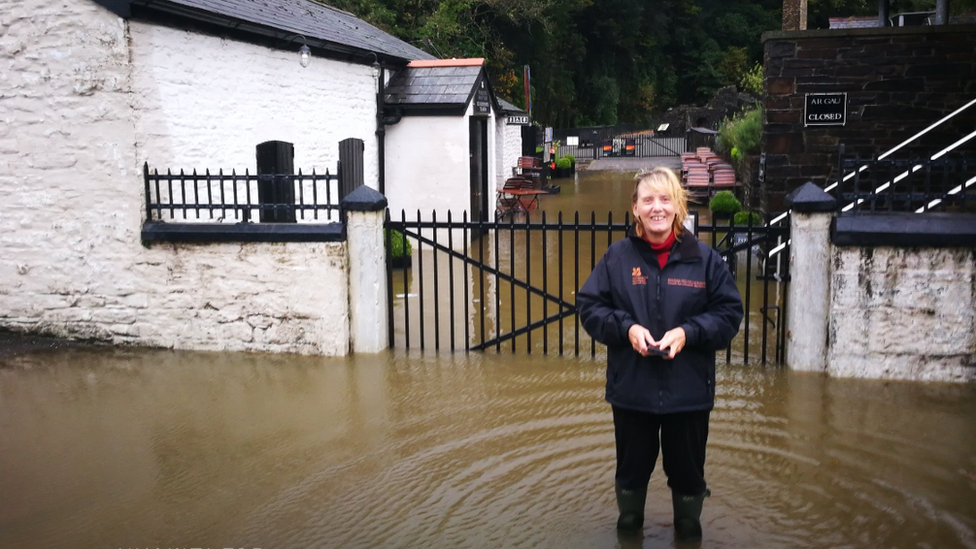 Woman standing in flood water in Aberdulais