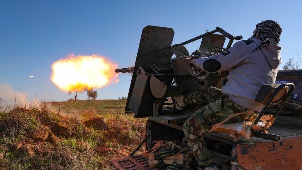 A Turkish-backed Syrian fighter fires a lorry-mounted gun in Idlib. Photo: February 2020