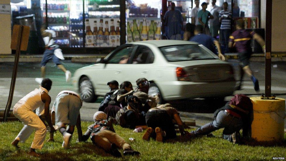 Protesters run to take cover after shots were fired in a police-officer involved shooting in Ferguson, Missouri August 9, 2015.