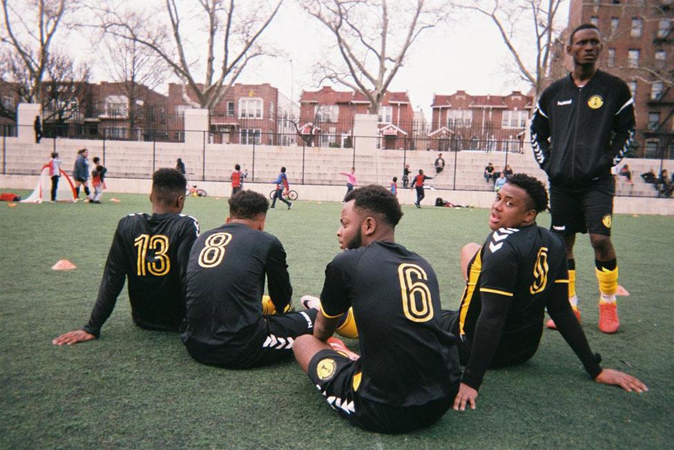 Football players sit on the ground on a football pitch