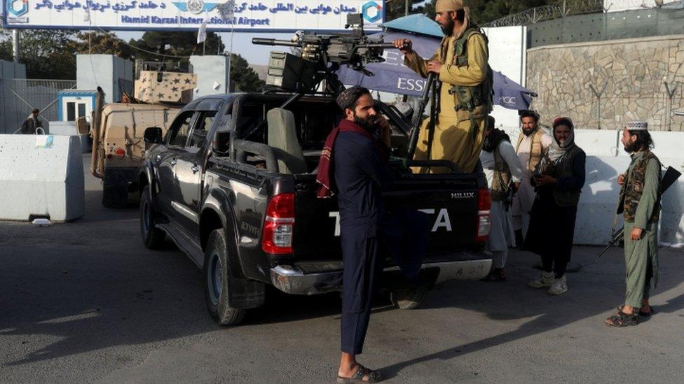 Members of the Taliban guard the entrance to Hamid Karzai International Airport in Kabul, Afghanistan