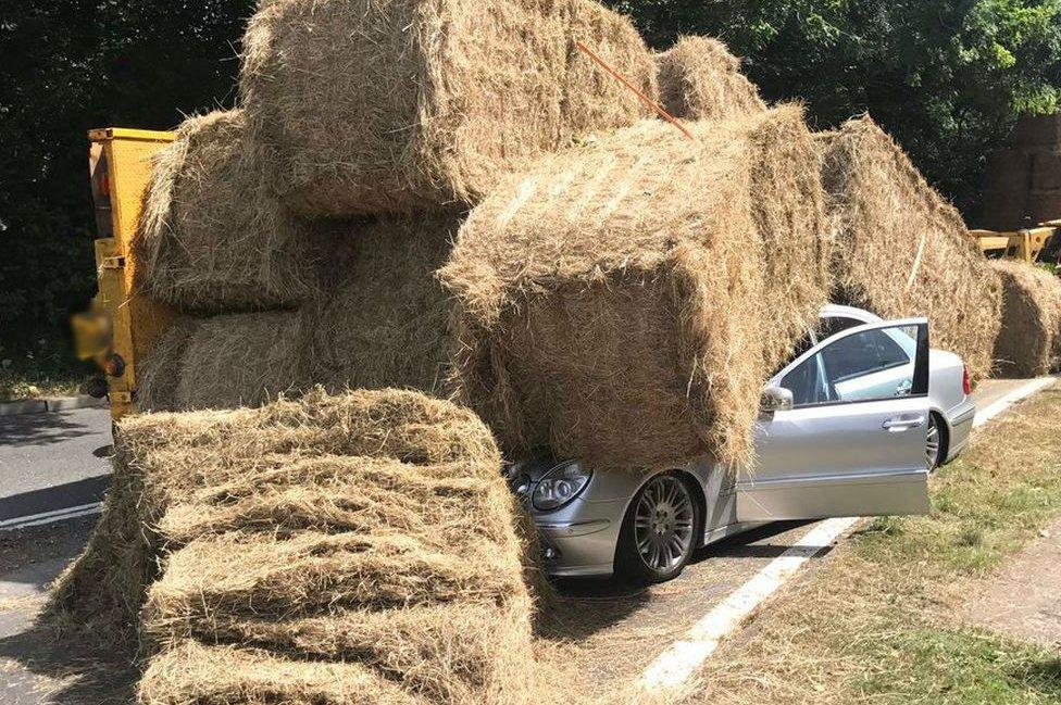 Mercedes car under hay bales