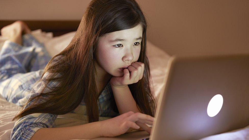 Child looking sadly at a laptop