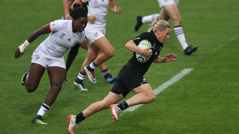 a black fern player running across the pitch chased by red roses players during the 2017 world cup final