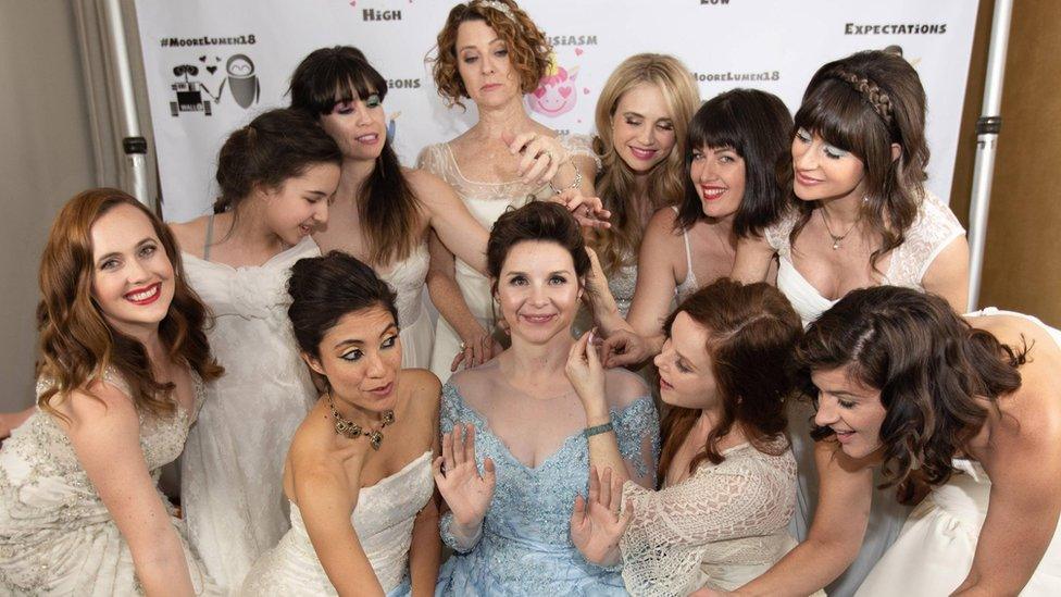 Audrey Moore in her blue wedding dress surrounded by her friends in their old dresses