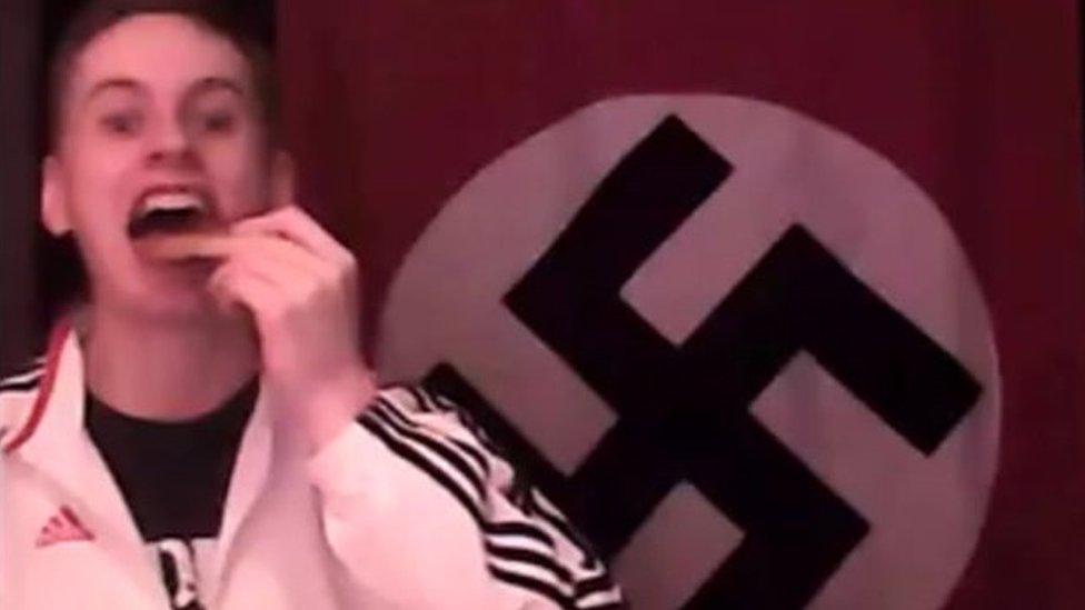 Zack Davies in front of Nazi flag