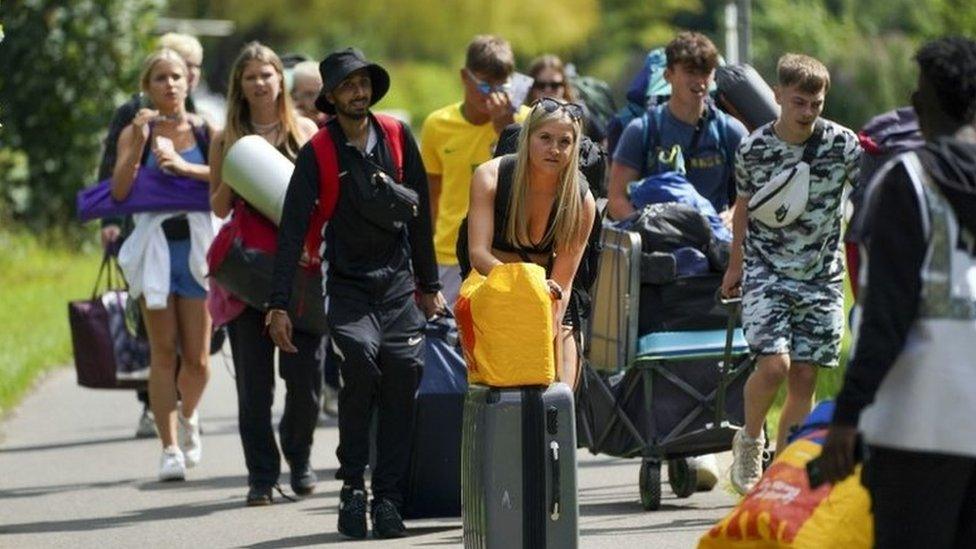 Festival goers walk along the towpath of the River Thames as they arrive for the Reading Festival at Richfield Avenue