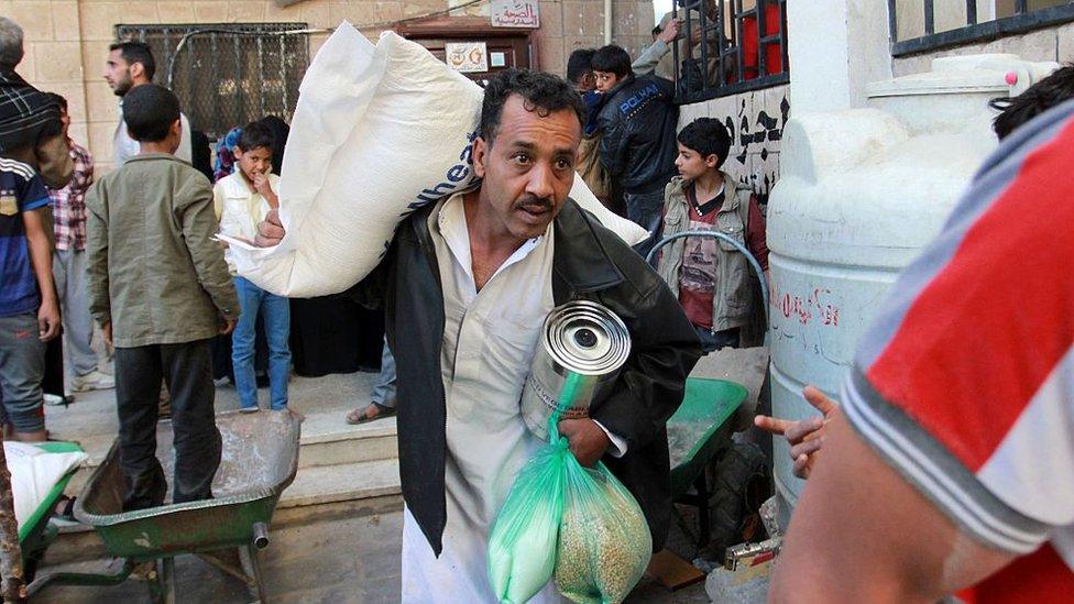 Displaced Yemenis receive food aid distributed by the United Nations in Sanaa on 5 December 2016