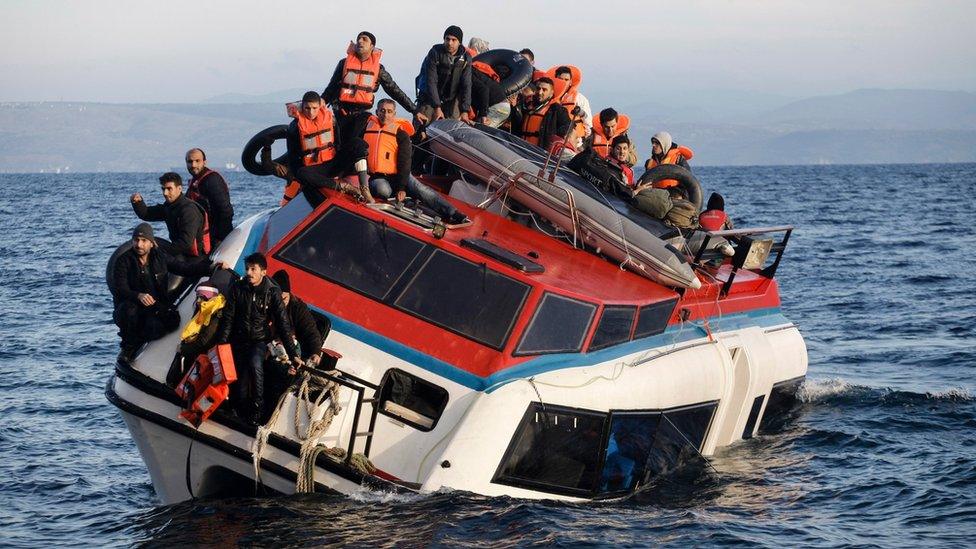 People sit atop a heavily-listing small vessel as they try to travel from the Turkish coast to Skala Sykaminias on the north-eastern Greek island of Lesbos on (30 Oct. 2015)