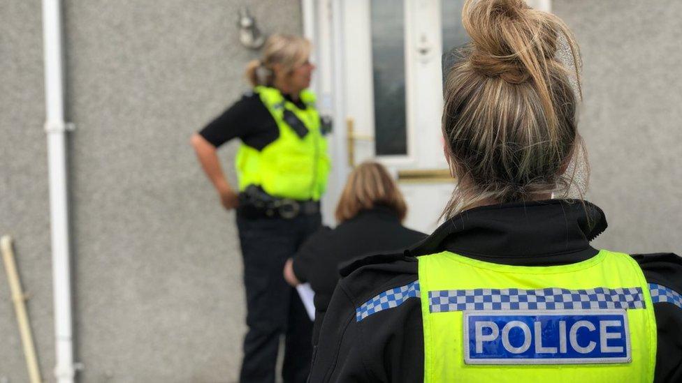 Police officers outside house