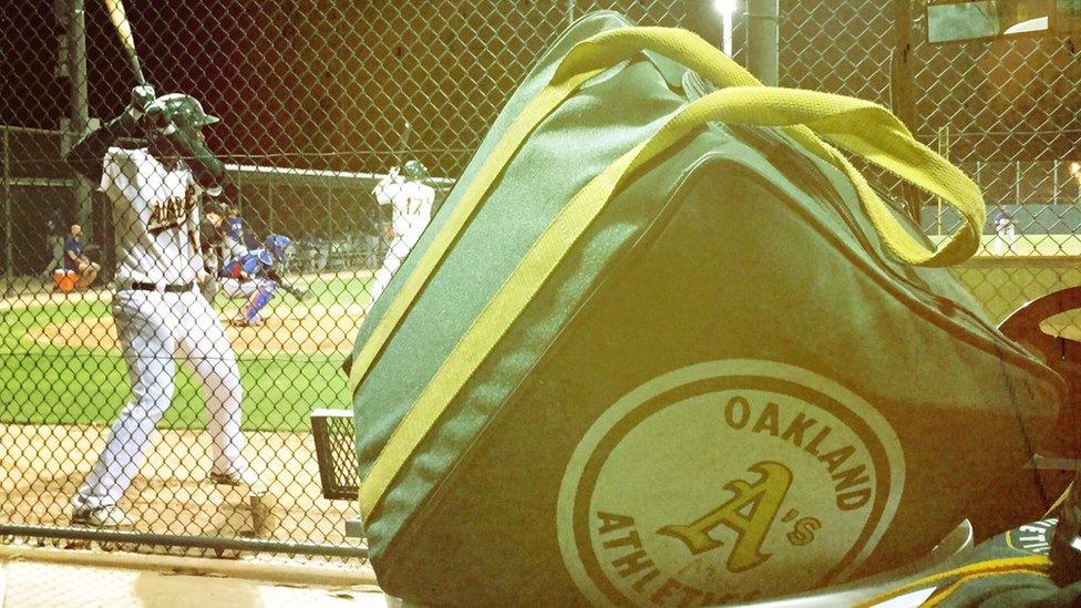 An A's batter waits on deck.