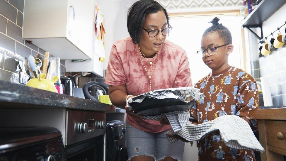 A mother and son prepare to put a dish in the oven