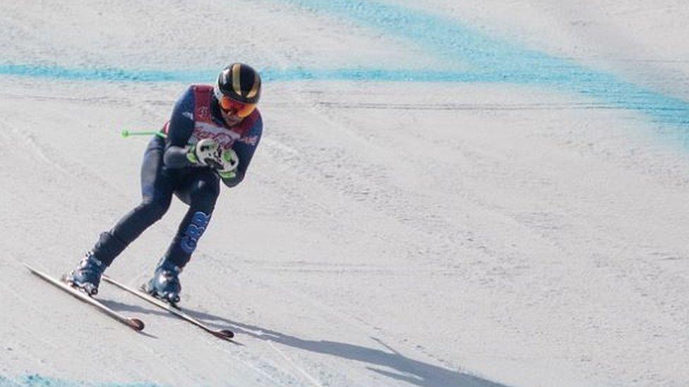 Chris Lloyd skiing down slope on snow