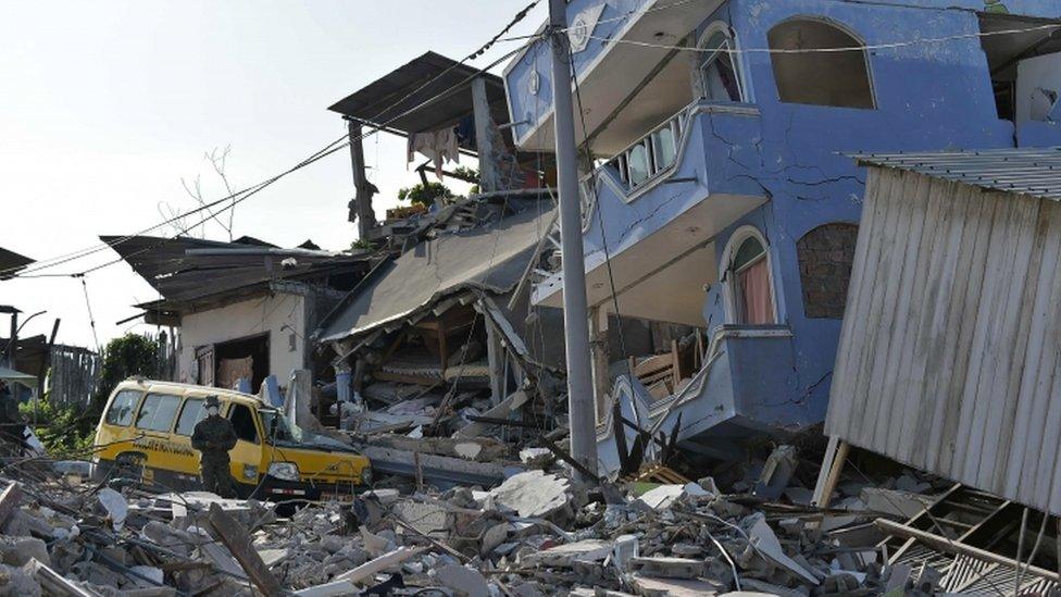 A soldier outside a badly damaged house from Ecuador's earthquake