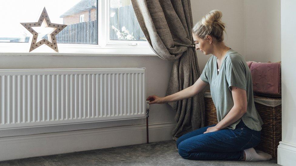 Woman adjusting radiator valve