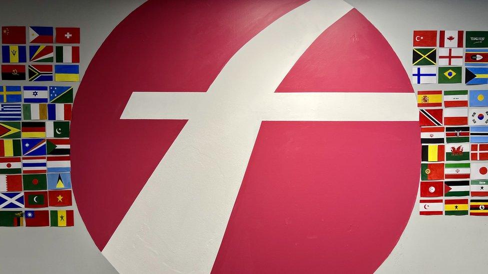 Painted flags and the First West of England logo on a wall at a Bristol bus depot