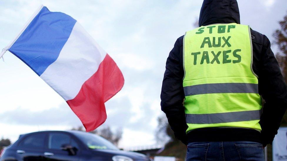 Message on a protestor's vest saying 'stop aux taxes'.