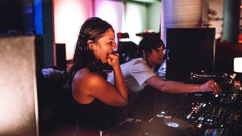 Woman looking nervous while learning to DJ