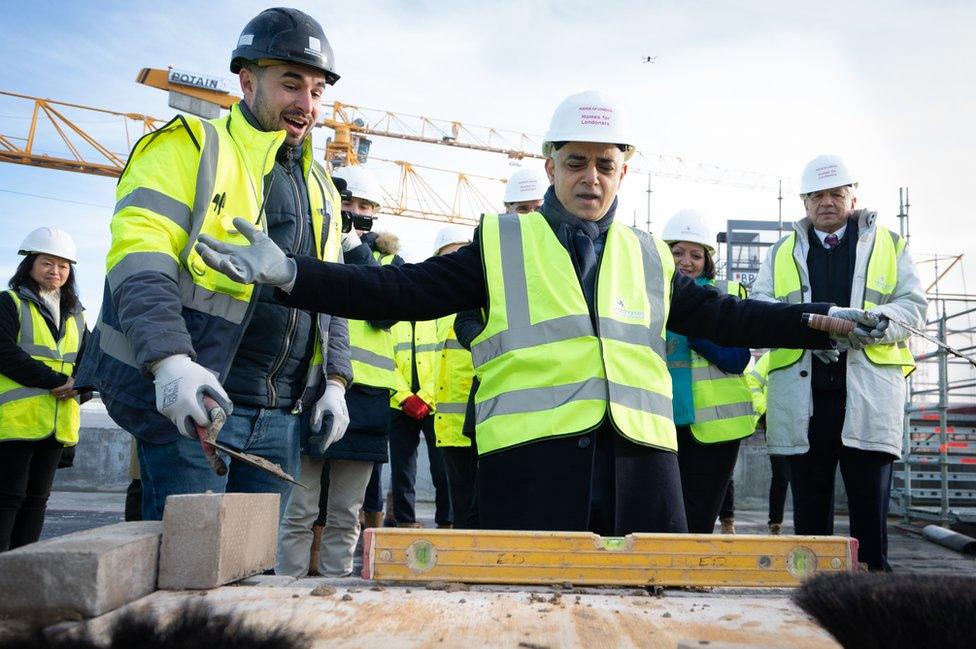 Mayor of London Sadiq Khan tries his hand at bricklaying during the topping out ceremony of a new affordable housing development in the Royal Docks