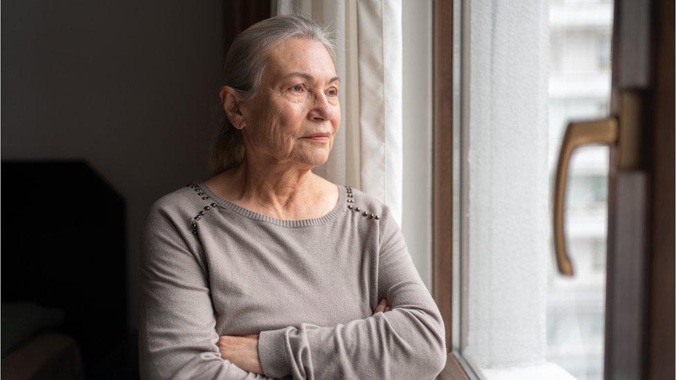 Older woman looking out the window