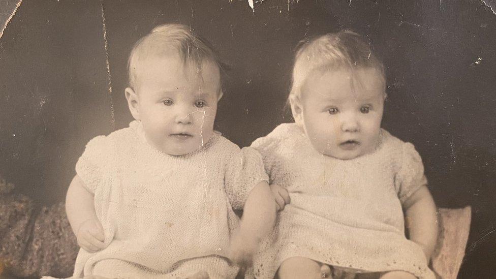 Two young girls wearing identical outfits