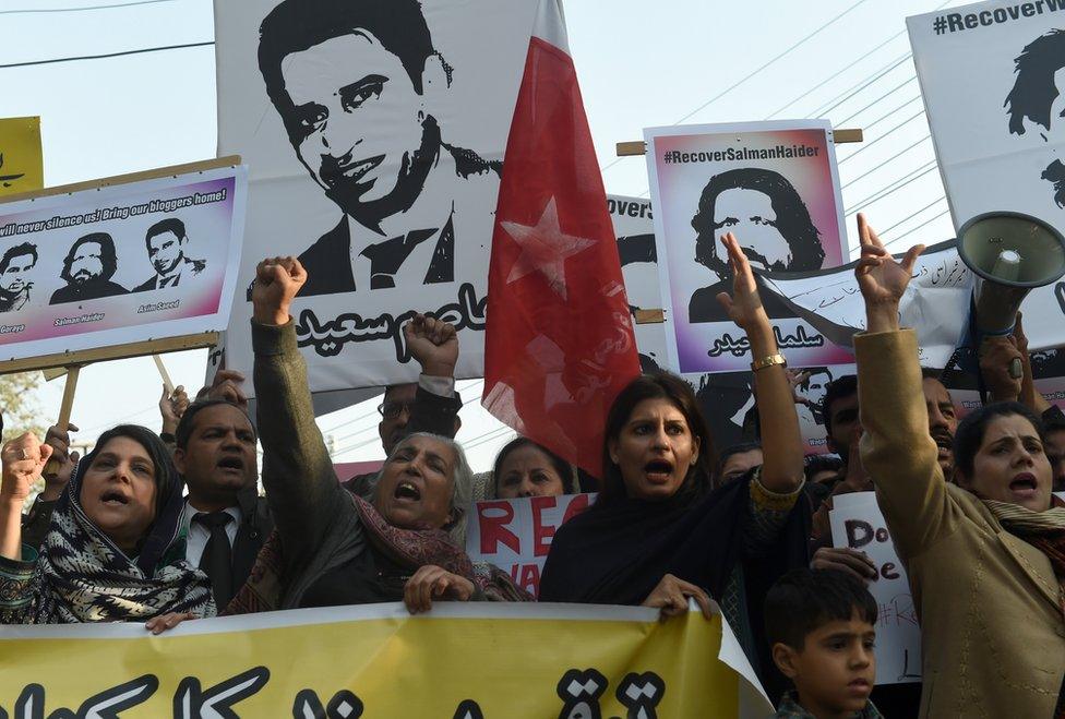 Pakistani rights activists hold pictures of disappeared bloggers during a protest in Lahore on 12 January, 2017.