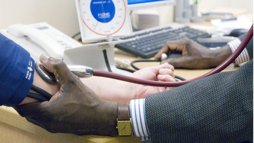 A GP checking a patient's blood pressure