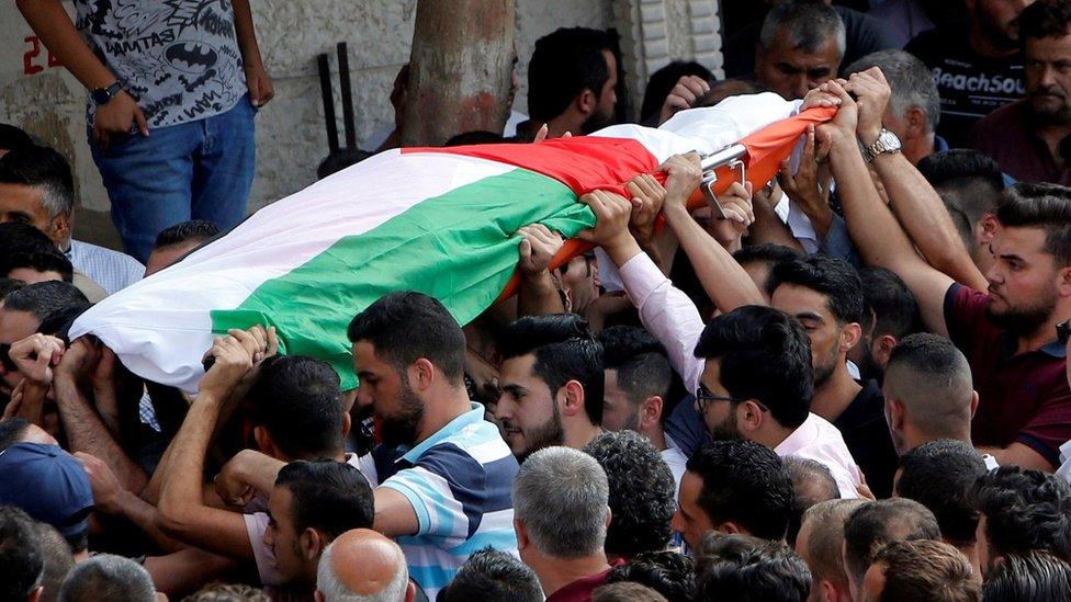 Mourners carry the body of Palestinian woman Aisha Rabi, who was killed when a stone hit her car in the occupied West Bank on 12 October