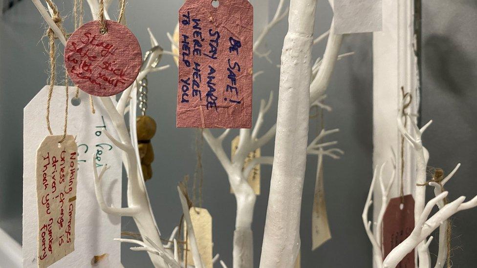 Messages on labels hanging from a small white tree