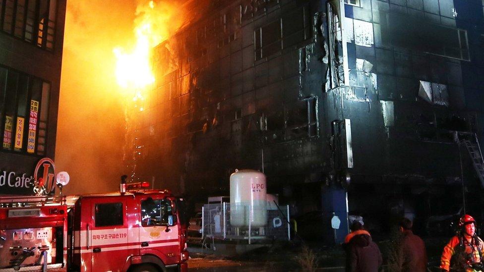 A fire engine and firefighters at the scene of the blaze at night time