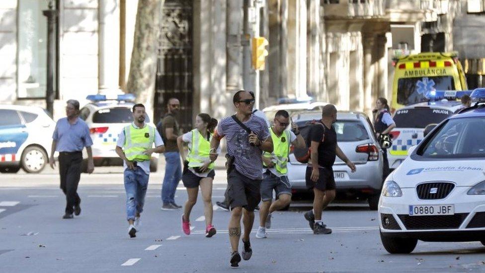 Police and emergency workers set up a security perimeter near where a van was driven into pedestrians in Barcelona (17/08/17)