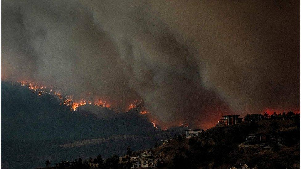 Smoke billows from a spreading wildfire