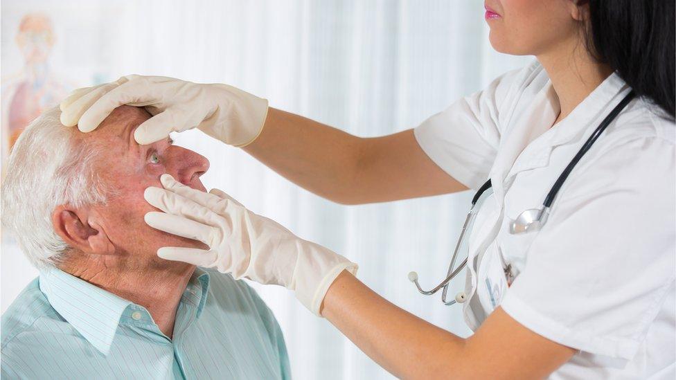 Elderly man having his eyes examined