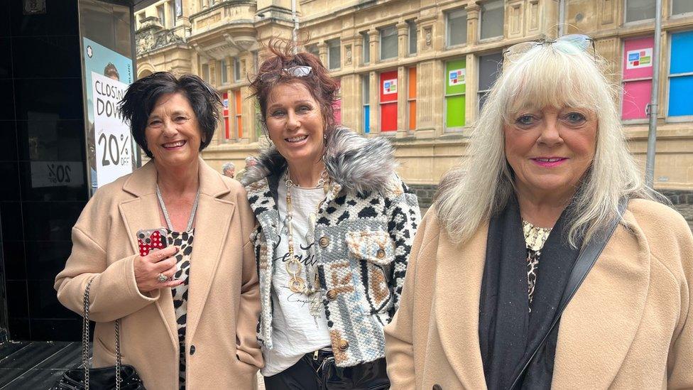 three women standing in front of Howells